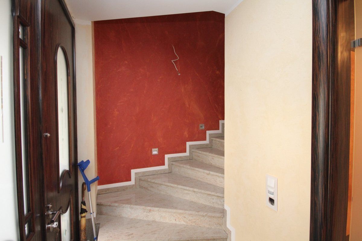 Treppenhaus mit roter Marmorputzwand